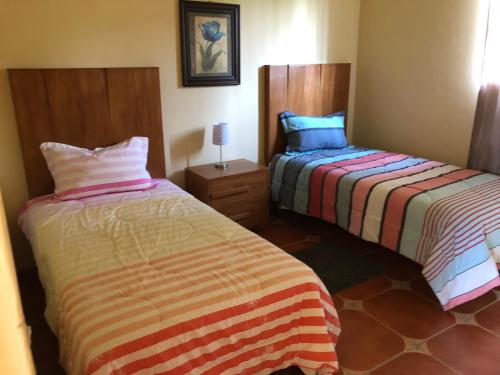 deux lits côte à côte dans une pièce dans l'établissement Cabaña Tequila Pueblo Mágico 1, à Tequila