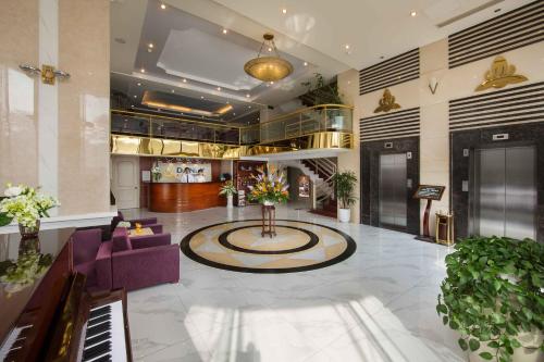 a lobby with a purple couch and a piano at Danly Hotel in Hanoi