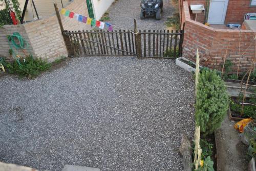 a garden with a wooden fence and a driveway at Ruca Kiñe Hostel in Las Grutas