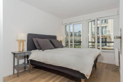 une chambre avec un lit blanc et une fenêtre dans l'établissement LOVELY APARTMENT CLOSE TO A BIG SHOPPING MALL, à Serris