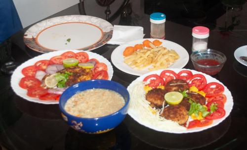 a table topped with plates of food and dip at Heather Home Stay in Cochin