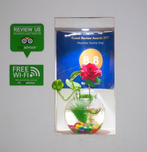 a flower in a glass vase with balls in a box at Heather Home Stay in Cochin