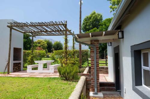 a pergola with a picnic table in a yard at Sweetwater Guesthouse in Wellington