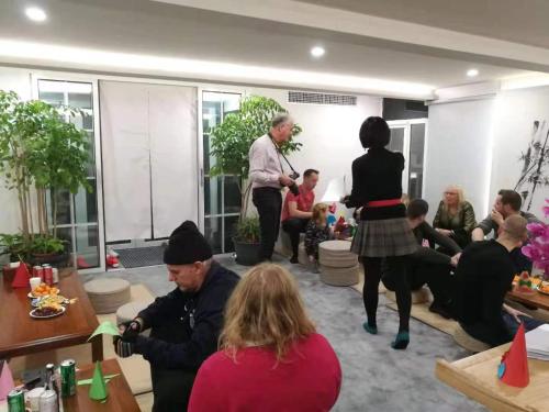 a group of people sitting in a room with people standing at Xingshe Alley Courtyard Hotel Beijing Wangfujing Forbidden City Branch - Breakfast included & English speaking reception & Free WiFi and Laundry room & Hutong Culture & Cat-keeping & Flower-growing Terrace & One day tour service & Free coffee in Beijing