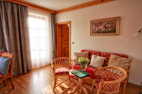 a living room with a couch and a table and chairs at Appartementhaus Sonne in Ramsau am Dachstein