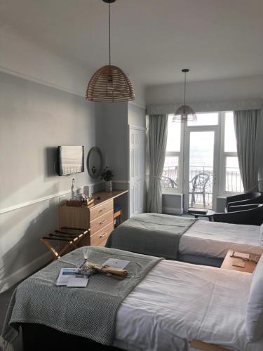 a hotel room with two beds and a television at The Elizabeth in Sidmouth