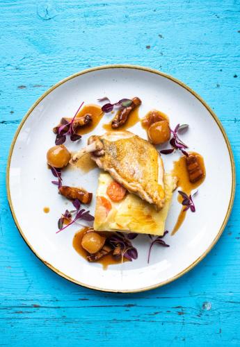 a plate of food with a piece of fish and vegetables at The Elizabeth in Sidmouth