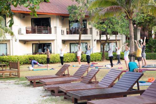 
a row of park benches in front of a building at Klong Prao Resort - SHA Extra Plus in Ko Chang
