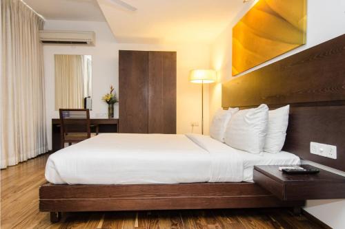 a hotel room with a bed and a desk at Springs Hotels and Spa in Bengaluru
