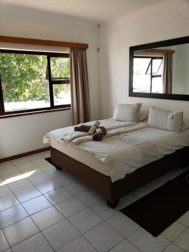 a bedroom with a bed with a teddy bear on it at Tourmaline Holiday House in Windhoek