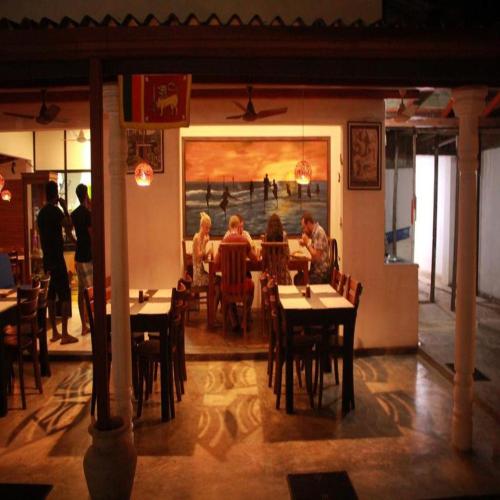 a group of people sitting at a table in a restaurant at Villa Koggala in Koggala