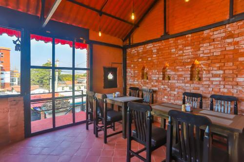 a restaurant with tables and chairs and a brick wall at Kathmandu Cottage - Boutique in Kathmandu