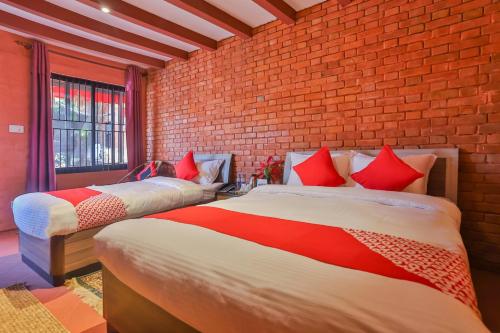 two beds in a room with a brick wall at Kathmandu Cottage - Boutique in Kathmandu