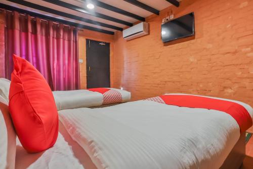 two beds with red pillows in a room at Kathmandu Cottage - Boutique in Kathmandu