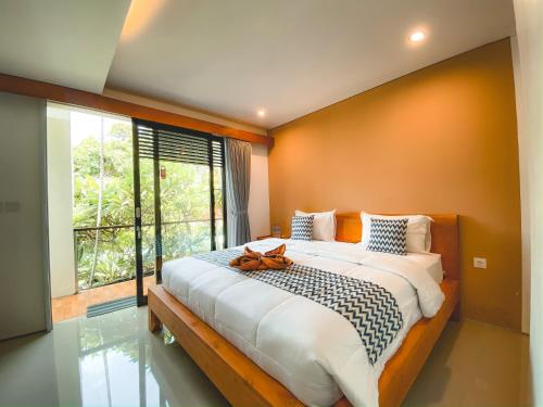 a bedroom with a large bed with a large window at Radha Homestay in Sanur