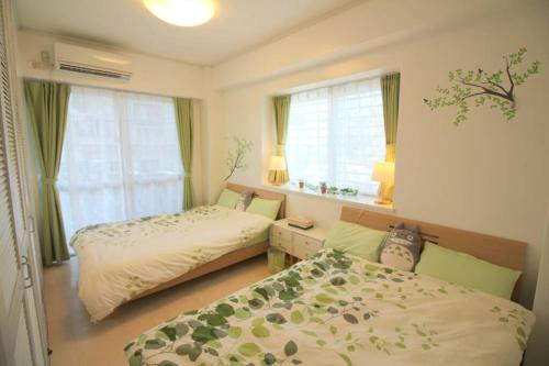 a bedroom with two beds and a window at 沖縄ライフインゼファー Okinawa Totoro House in Tōbaru