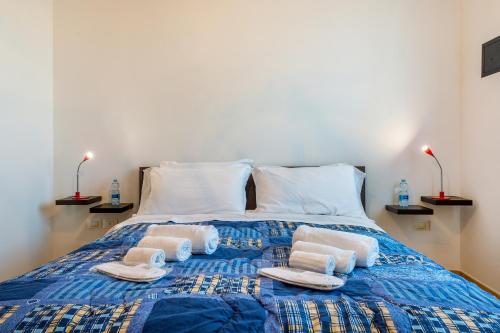 1 dormitorio con 1 cama con toallas y 2 lámparas en GoodStay Archimede Apartment, en Lecce