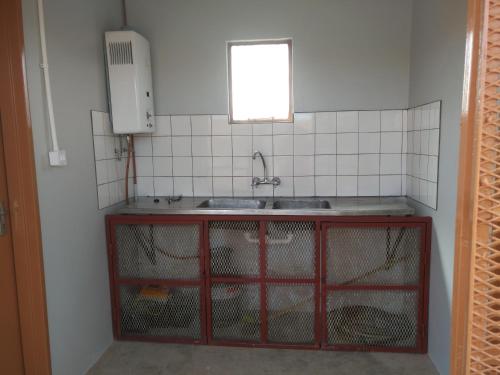 a kitchen with a sink and a counter with chickens in it at Old Bridge Camping in Maltahöhe