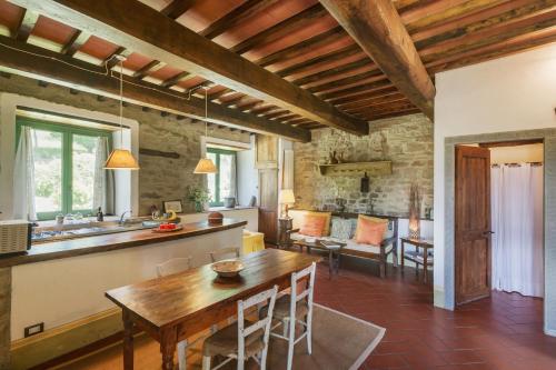 a kitchen and living room with a wooden table at Resort con vista nel Chianti Rufina in Londa
