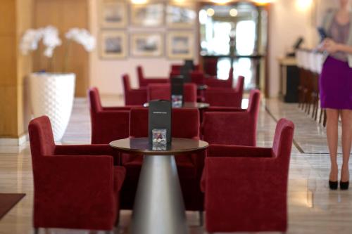 a dining room with red chairs and a table with a laptop at Radisson Blu Martinez Beirut in Beirut