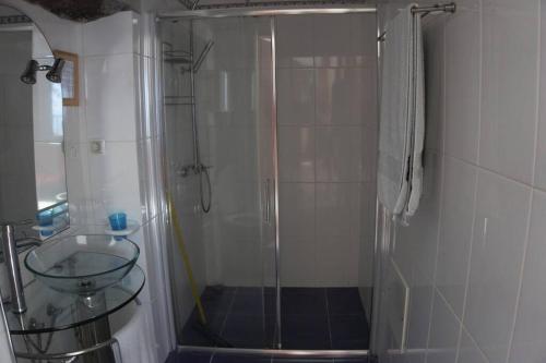 Un baño con ducha de cristal con lavabo. en Raposeira de São João, the feeling of peace, space and quiet, Whole villa is yours, en Fajã da Ovelha