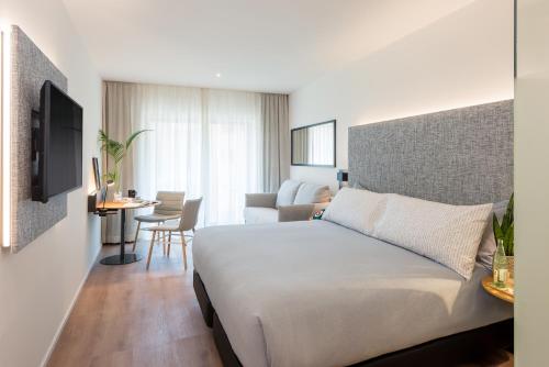 a bedroom with a bed and a living room at INNSiDE by Meliá Zaragoza in Zaragoza