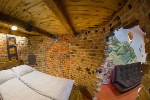 a room with a bed and a brick wall at Hotel Kocourkov in Hlinsko