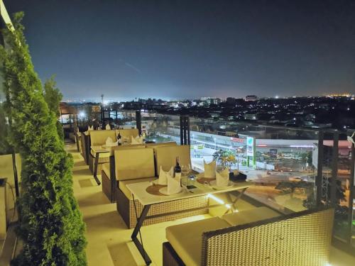 a restaurant with tables and chairs on a balcony at night at Sky dome resotel - โรงแรมสกายโดม รีโซเทล in Bangkok