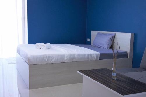 a blue bedroom with a bed with towels on it at H12, The Stylish Apartment in Hua Hin