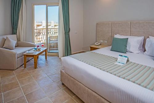 1 dormitorio con cama, sofá y balcón en Sunrise Aqua Joy Resort, en Hurghada