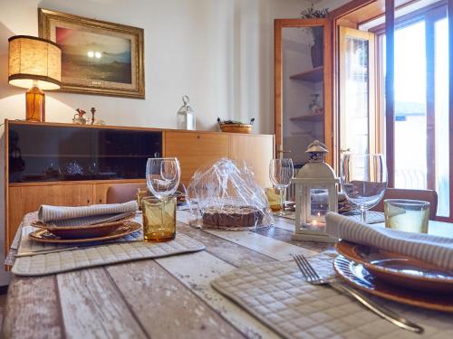 una mesa de madera con platos y vasos. en Appartamento Ghisallo, en Magreglio