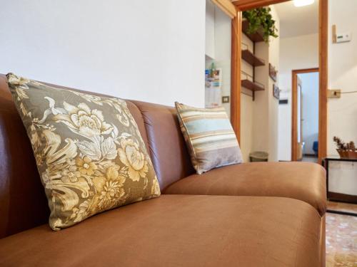 a brown couch with a pillow on it at Appartamento Ghisallo in Magreglio