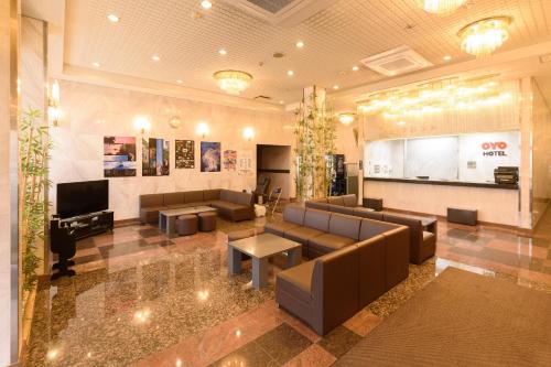 a lobby with couches and a tv in a building at Business Hotel Kawakami in Kumano