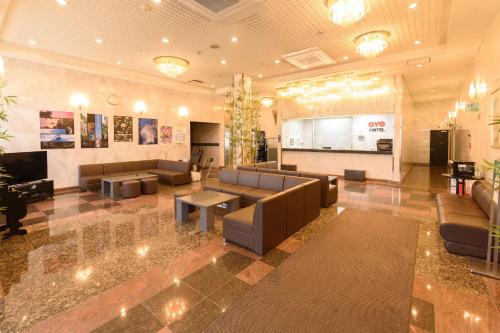 a lobby with couches and tables in a building at Business Hotel Kawakami in Kumano