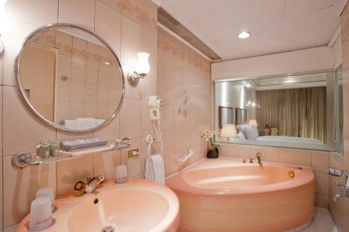 a bathroom with a tub and a sink and a mirror at Deja Vu Hotel in Taipei