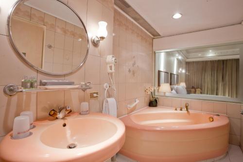 Deja Vu Hotel في تايبيه: حمام مع حوض ومغسلة ومرآة