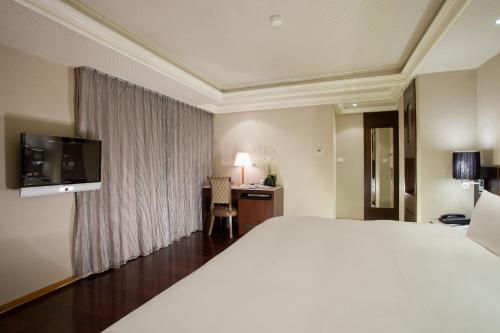 a hotel room with a large bed and a desk at Deja Vu Hotel in Taipei
