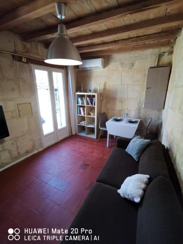 ein Wohnzimmer mit einem Sofa und einem Tisch in der Unterkunft Charmante maison en Provence in Fontvieille