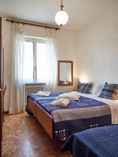 a bedroom with two beds and a mirror and a window at Appartamento Ghisallo in Magreglio
