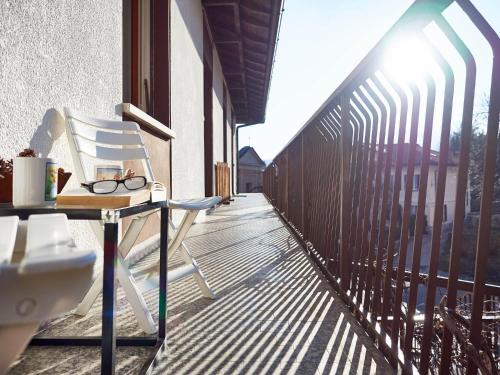 a balcony with a chair and a table on a porch at Appartamento Ghisallo in Magreglio