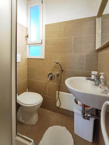 a bathroom with a toilet and a sink at Appartamento Ghisallo in Magreglio