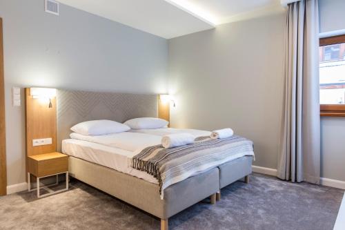 a bedroom with a bed with two towels on it at Royal Hill Residence in Zakopane