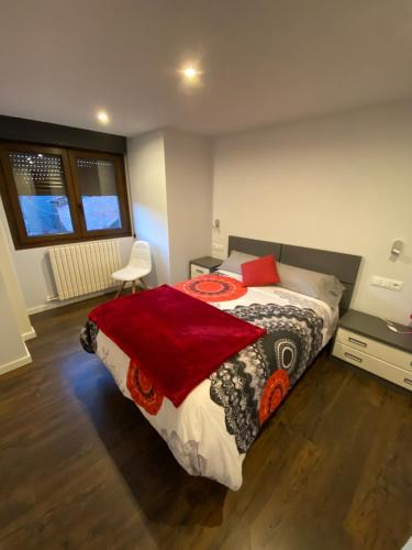 a bedroom with a bed with a red blanket on it at Casa Migalet in Laspaúles