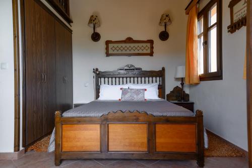 a bedroom with a wooden bed with a wooden headboard at AnnaDes Apartments & Studios Chios in Karfas