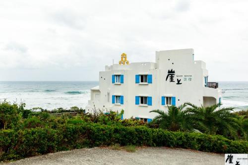 een wit gebouw op het strand bij de oceaan bij 崖上民宿 Cliff House B&B in Fengbin
