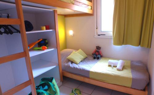 a small childs bedroom with a bunk bed and a ladder at VVF Montagnac Hérault in Montagnac