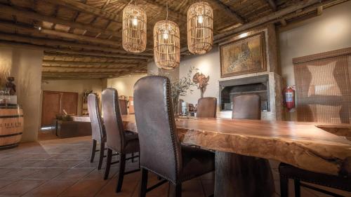 a dining room with a large wooden table and chairs at Bagatelle Kalahari Game Ranch in Hardap