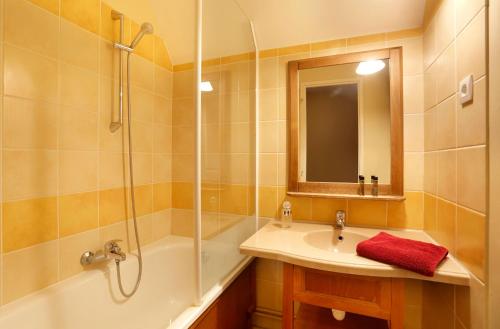 a bathroom with a tub and a sink and a shower at Résidence Lac Mondésir in Monflanquin