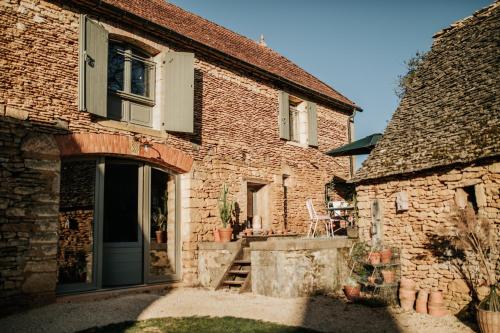 um edifício de tijolos com uma porta e um alpendre em Maison d'hôtes Bel Estiu em Saint-Geniès