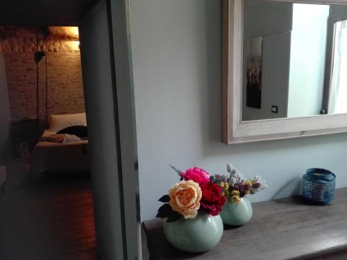 two vases with flowers on a table in a room at Only for two Giumbabulla in Ragusa